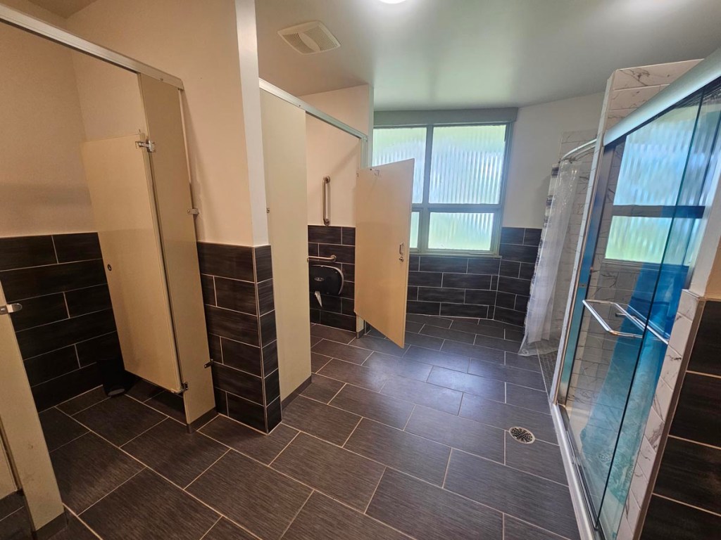 Bathroom area with 2 cubicles and 2 showers